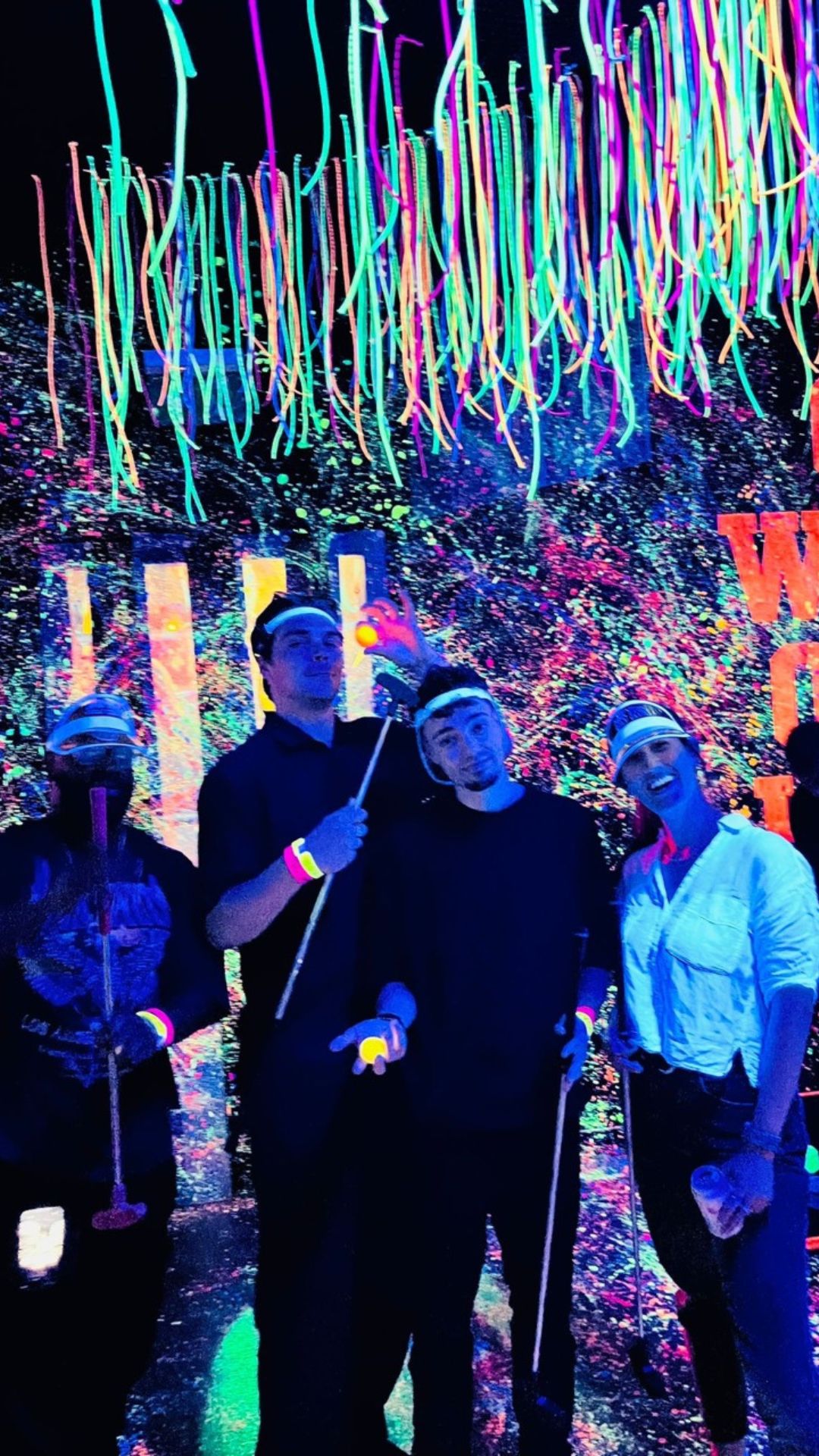 A group photo of the team posing with golf putters