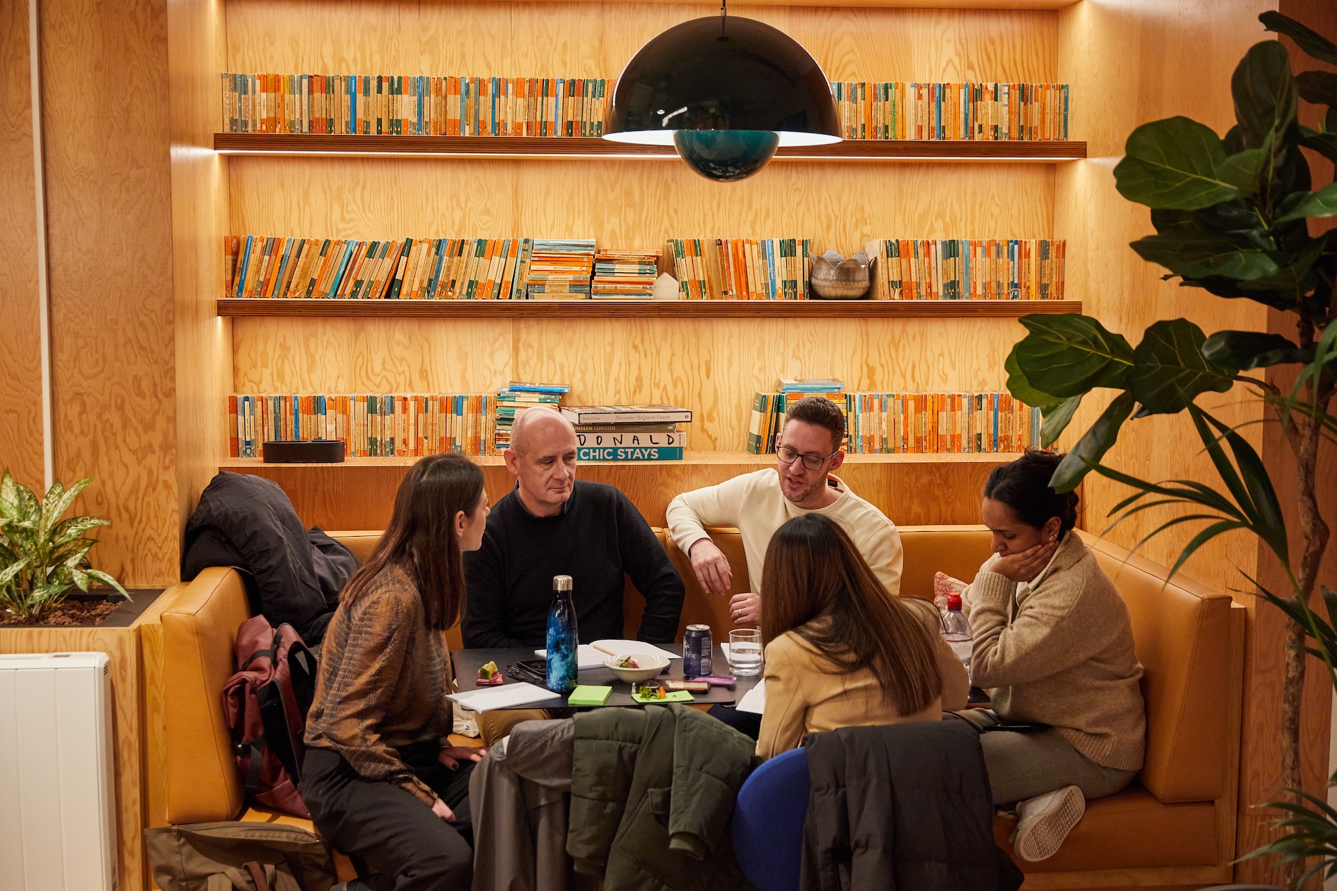 A group of people working in front of a bookshelf