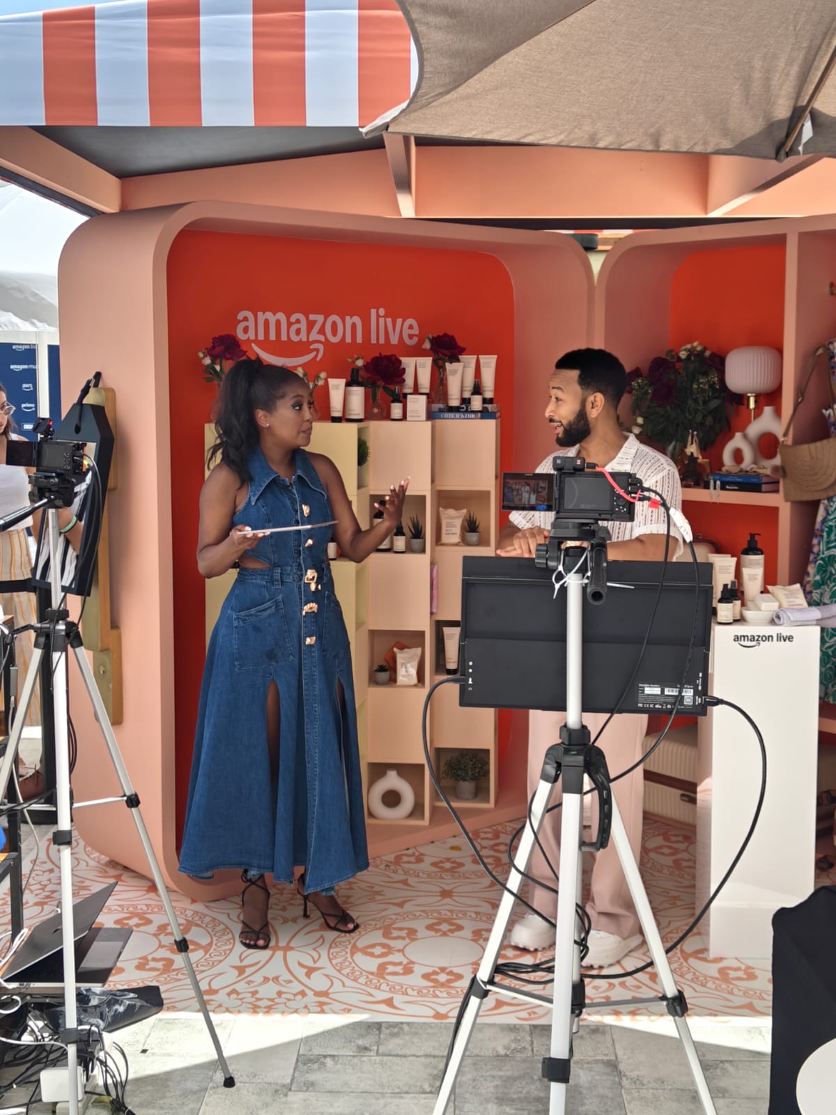 John Legend is interviewed in front of cameras by a lady